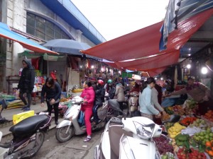 Dans le marché du quartier, les allées sont étroites, mais les scooters s'engagent quand même !