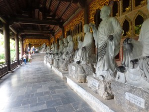 Alignement de statues de Buddha. Les statuettes dorées sont tout le long derrière les statues